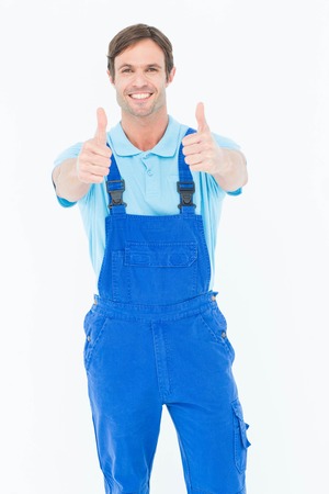 Portrait of male carpenter showing thumbs up over white backgroundの写真素材