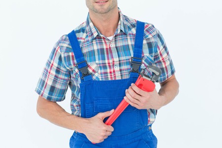 Cropped image of plumber holding monkey wrench over white backgroundの写真素材