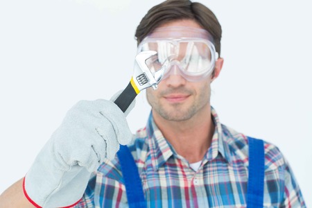 Close-up of plumber holding adjustable wrench over white backgroundの写真素材