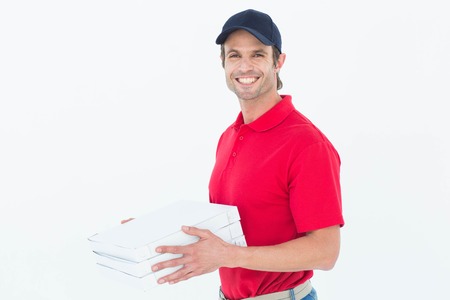 Portrait of happy delivery man holding pizza boxes on white background