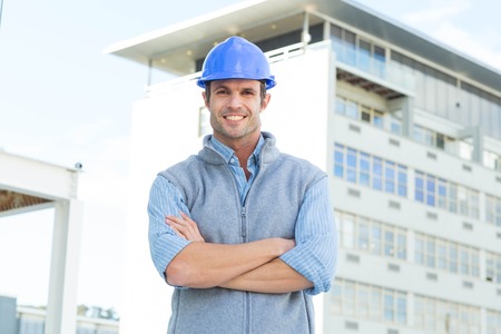 Portrait of confident male architect standing arms crossed outside building