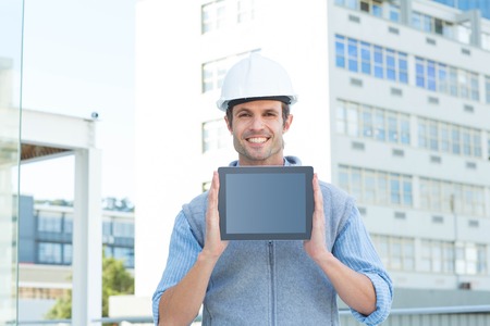 Portrait of handsome male architect showing digital tablet outdoors