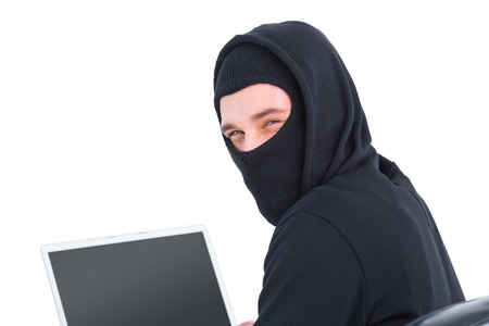 Hacker using laptop and looking at camera on white backgroundの写真素材