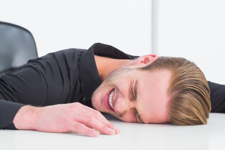Stressed businessman banging his head on white backgroundの写真素材