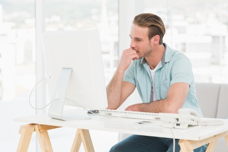 Concentrated businessman working with computer in his officeの写真素材