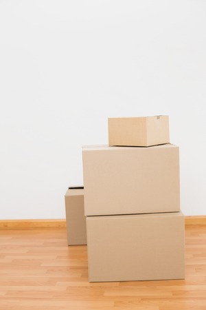 Pile of cardboard boxes on the floor at home in the living room