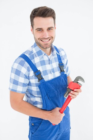 Portrait of confident young male repairman holding adjustable pliers on white backgroundの写真素材