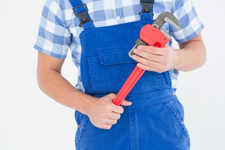 Cropped image of young male repairman holding adjustable pliers on white backgroundの写真素材