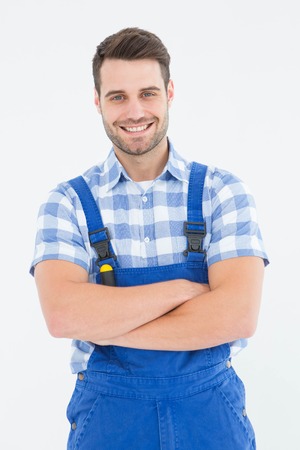 Portrait of confident male handyman standing arms crossed on white backgroundの写真素材