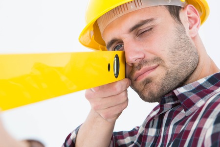 Close-up of technician using spirit level on white background