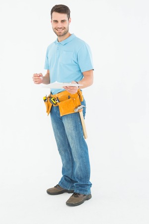 Portrait of smiling construction worker holding clipbard over white backgroundの写真素材