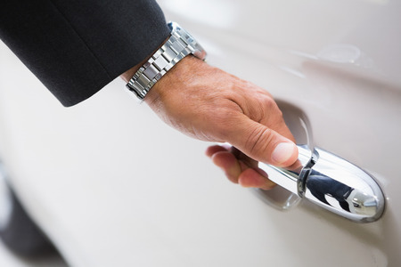 Man holding a car door handles at new car showroom