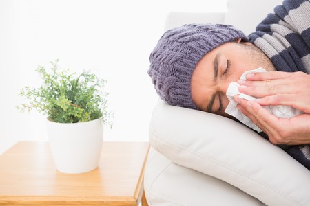 A sick man lying on the sofa in the living roomの写真素材