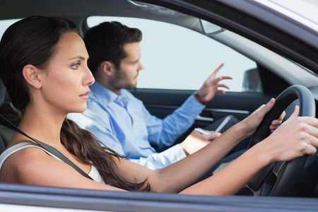 Young woman getting a driving lesson in the car