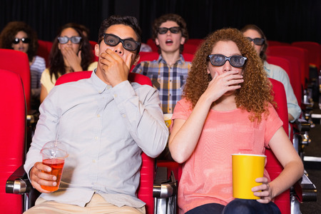 Young friends watching a 3d film at the cinema