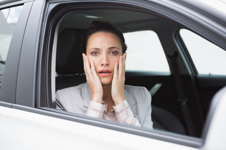 Nervous businesswoman looking at camera in her car