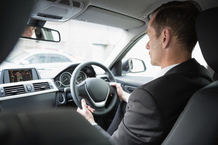 Businessman in the drivers seat in his car