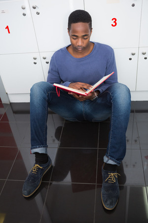 University student studying on the floor at the collegeの写真素材