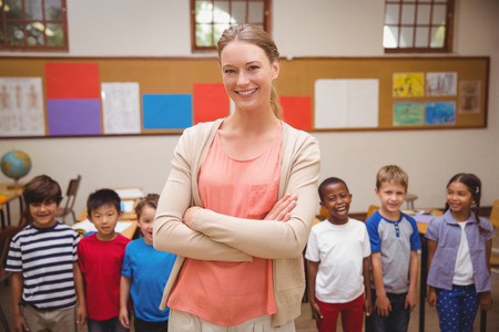 Teacher and pupils smiling at camera in classroom at the elementary schoolの写真素材