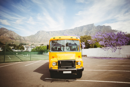 Yellow school bus waiting for pupils outside the elementary schoolの写真素材