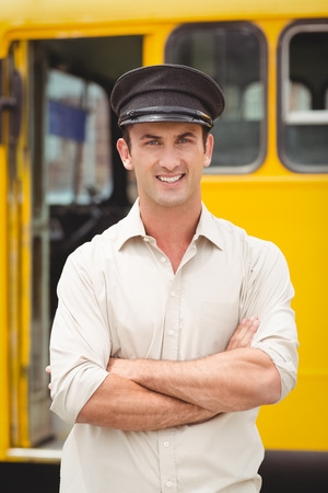 Smiling bus driver looking at camera outside the elementary schoolの写真素材