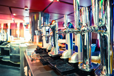 Shiny beer taps in a row in a barの写真素材
