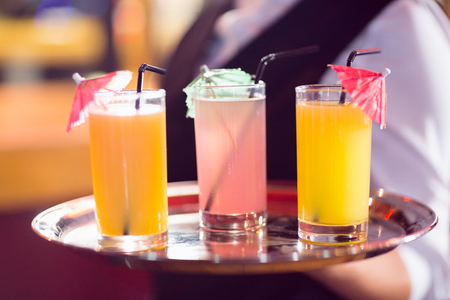 Barmaid holding tray of cocktails in a bar