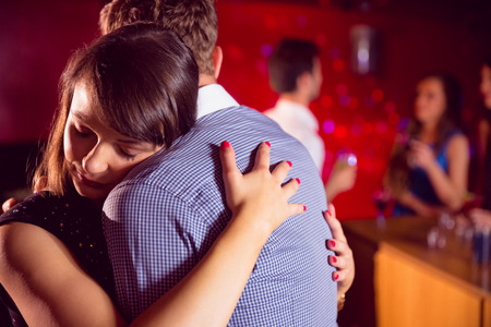 Cute couple slow dancing together at the nightclubの写真素材