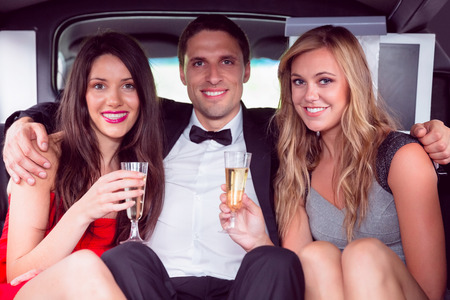 Pretty girls with ladies man in the limousine on a night out