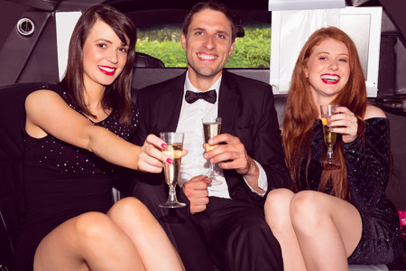 Pretty girls with ladies man in the limousine on a night outの写真素材
