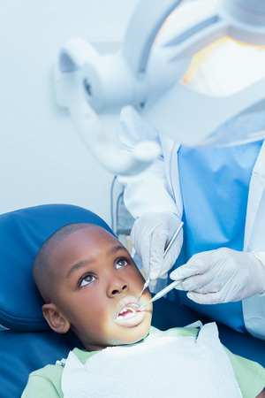 Close up of boy having his teeth examined by a dentistの写真素材