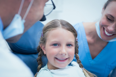 Close up portrait of girl having her teeth examined by dentistの写真素材