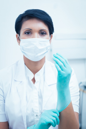 Portrait of female dentist wearing surgical mask and glovesの写真素材