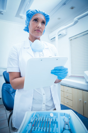 Serious female dentist checking reportsの写真素材