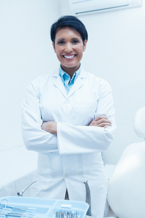 Portrait of smiling female dentist standing with arms crossedの写真素材