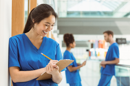Medical student taking notes in hallway at the universityの写真素材