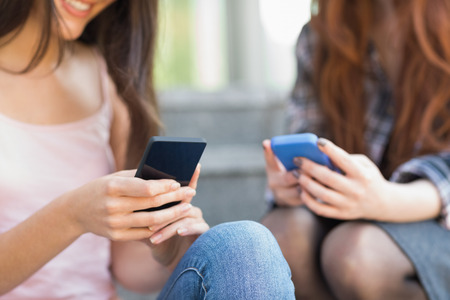 Students using their smartphones together at the university