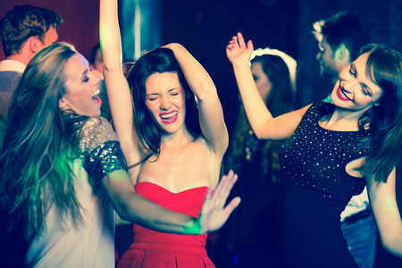 Happy friends having fun together at the nightclubの写真素材