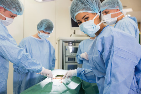 Medical student looking at camera during practice surgery at the universityの写真素材