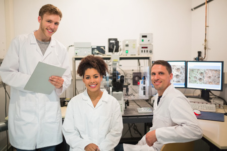 Biochemistry students using large microscope and computer at the university