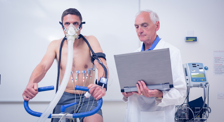 Man doing fitness test on exercise bike at the medical centreの写真素材