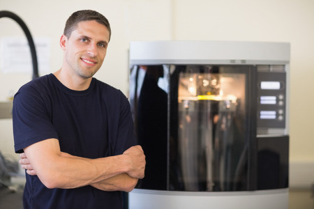 Engineering student smiling beside 3d printer at the universityの写真素材