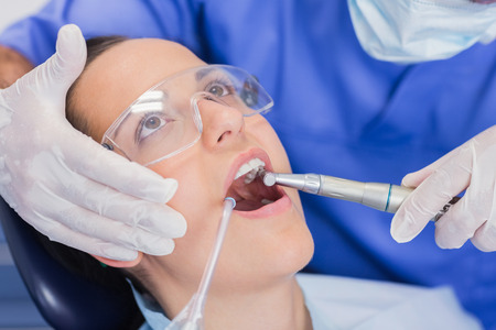 Dentist examining a patient with tools in dental clinicの写真素材