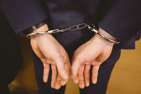 Hands of businessman with handcuffs in the court roomの写真素材