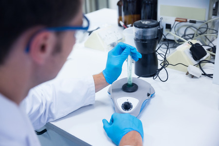 Close up of a chemist using a centrifuge in the laboratory
