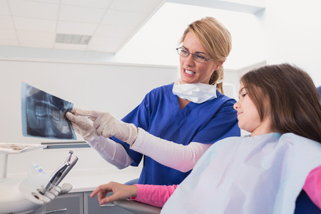 Pediatric dentist explaining to young patient the x-ray in dental clinicの写真素材