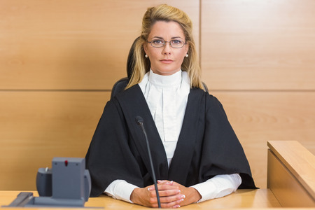 Stern judge looking at camera in the court roomの写真素材