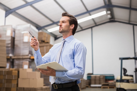 Side view of manager holding clipboard in the warehouseの写真素材