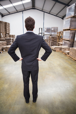 Warehouse manager standing hands on hips in warehouseの写真素材