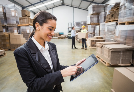 Female manager using digital tablet in warehouse Female manager using digital tablet in warehouse